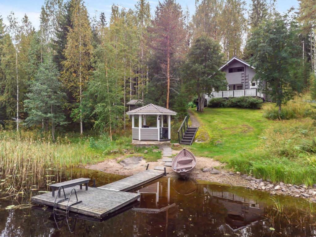 a house with a dock and a boat on the water at Holiday Home Kiikkukallio by Interhome in Hankamäki