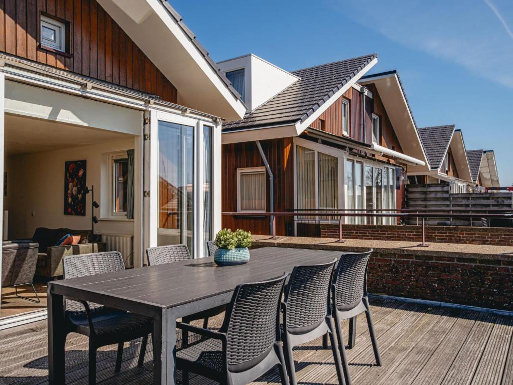 a table and chairs on a patio with a house at Apartment Oostergeest by Interhome in Uitgeest