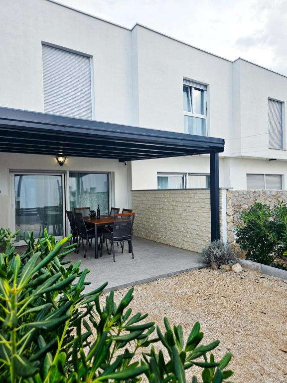 a patio with a table and chairs in front of a building at Roris House in Povljana