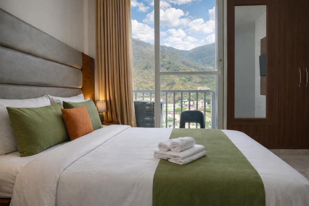 a bedroom with a large bed with towels on it at Ima Ganga Hotel - Aesthetic, Quite Mountain View Rooms In Upper Tapovan with netflix, free airport pickup for 7 or more nights booking in Rishīkesh