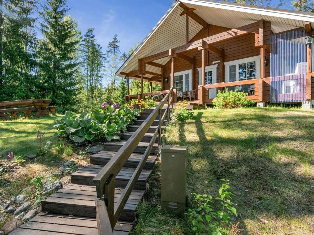 a house with a wooden staircase leading to a porch at Holiday Home Lehtimaja by Interhome in Tiitanvaara