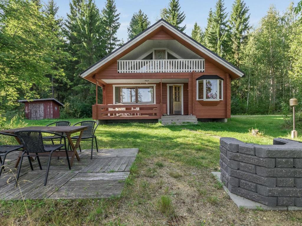 a log cabin with a table and chairs in the yard at Holiday Home 6440 by Interhome in Pihlajaniemi