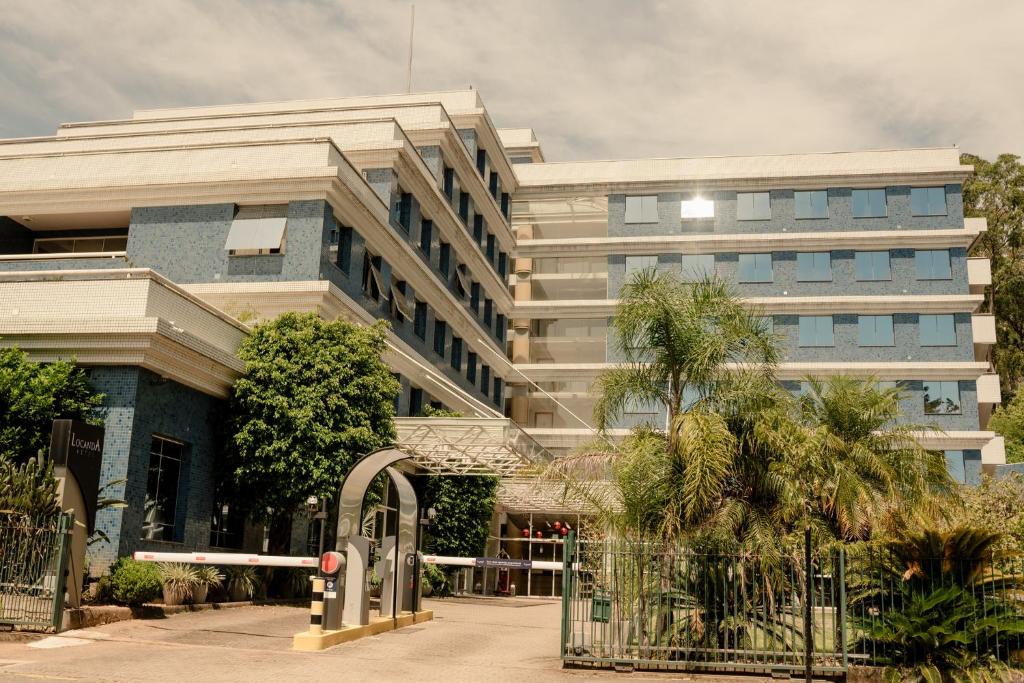 a large building with a gate in front of it at Locanda Hotel in Novo Hamburgo