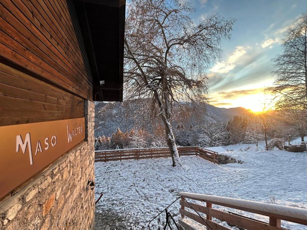 a sign on the side of a building in the snow at Maso Walter in Pradellan