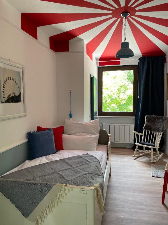 a room with a bed with a red and white ceiling at Gastwerk Waldfrieden in Gießen