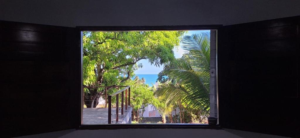 a window with a view of a palm tree at Mirante Rota do Mar in Maceió