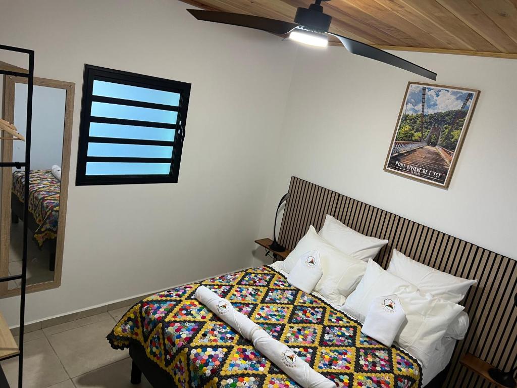 a bedroom with a bed with a comforter and pillows at ALHAMBRA location saisonnière in Sainte-Rose