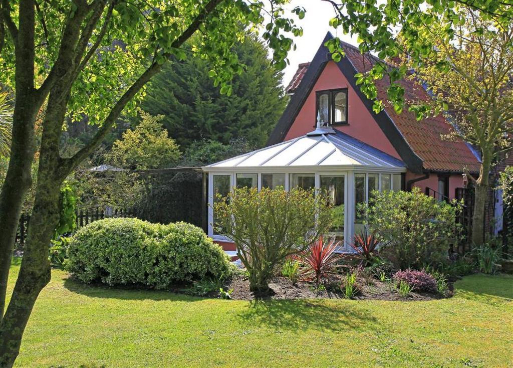 a house with a greenhouse in the yard at 1 Bed in Frostenden oc-phc in Frostenden