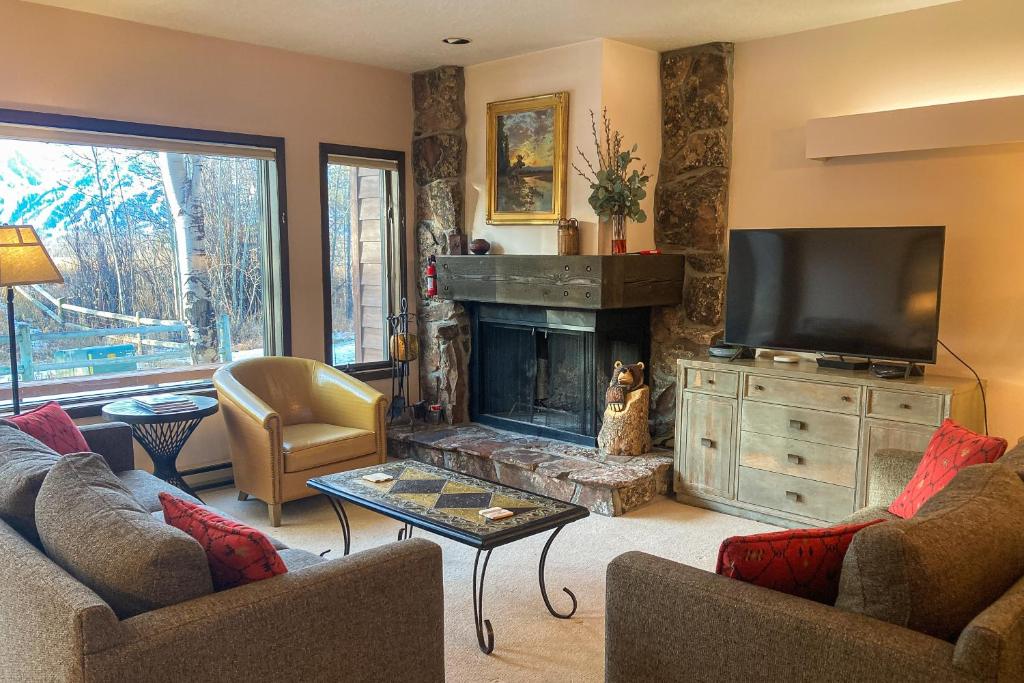 a living room with a fireplace and a tv at Teton Shadows Darwin F in Jackson