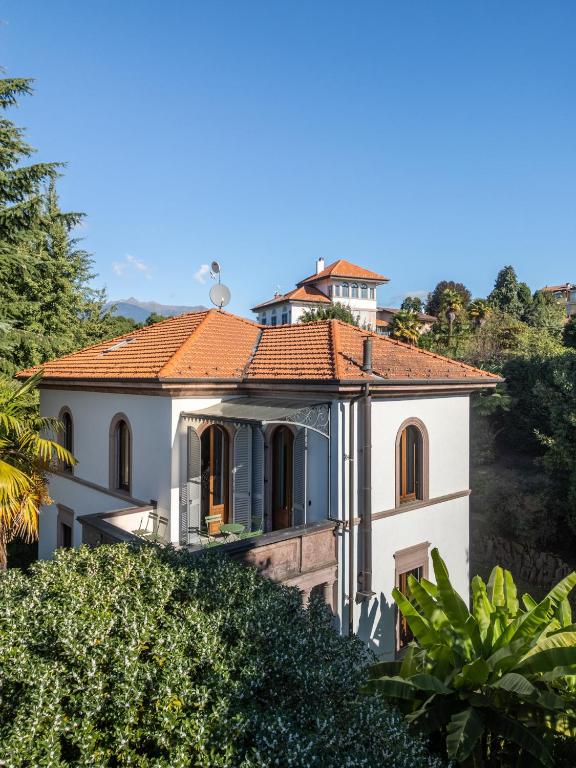 a large white house with an orange roof at Villa Cedro in Verbania