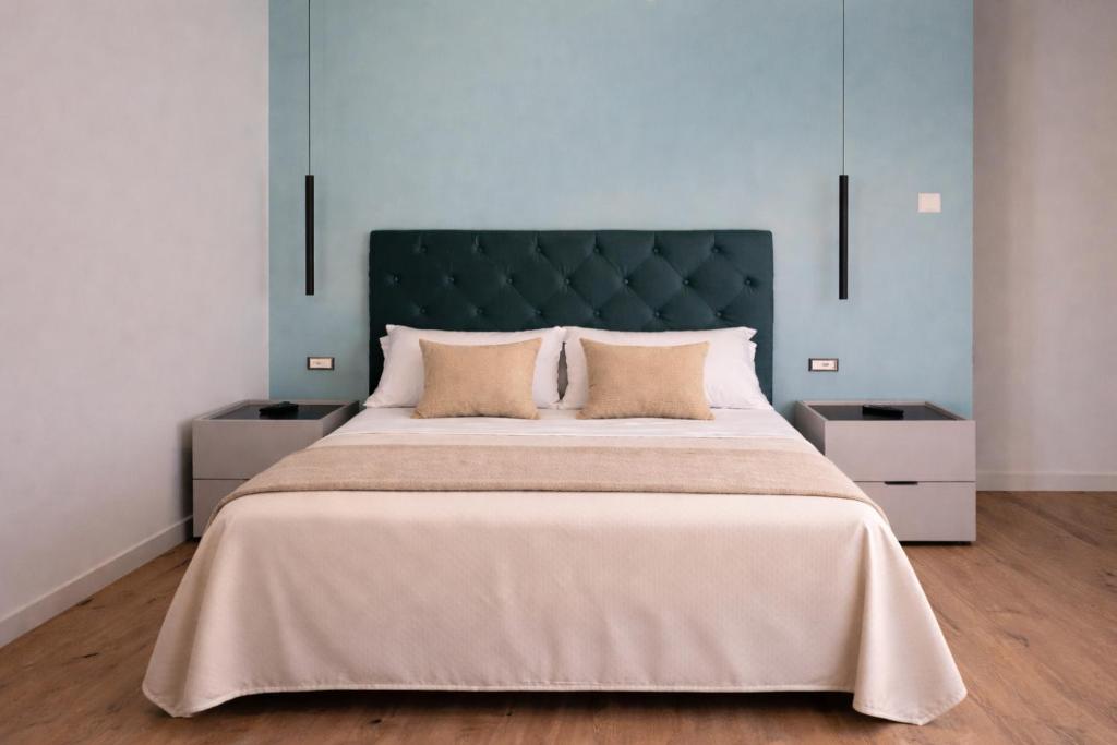 a bedroom with a large bed with a green headboard at Le Chiavi di Polidoro in Aversa