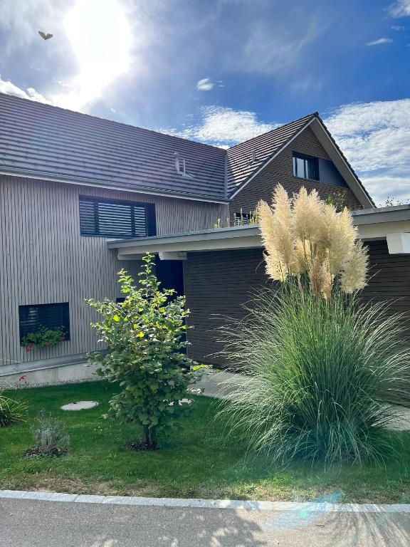 a house with a fence and plants in front of it at Ferienhausträume Oase Bodensee in Kreuzlingen