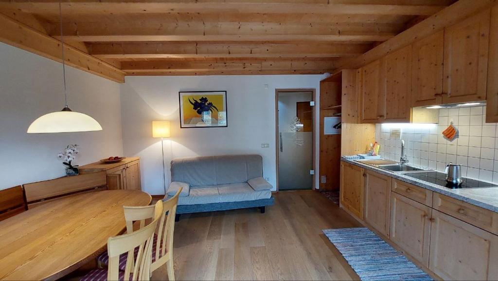 a kitchen with a table and a couch in a room at CHALET MARLENE - Ferienhaus in San Vigilio Di Marebbe