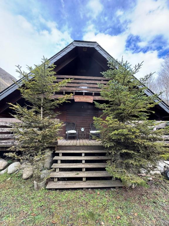 a log cabin with stairs leading up to a house at Les Vaillants Chalet - Vielle Aure in Vielle-Aure