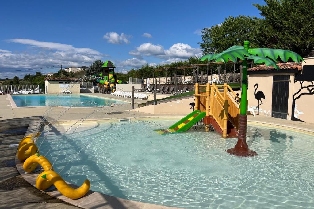 a swimming pool with a slide and a playground at Ludocamping in Lussas