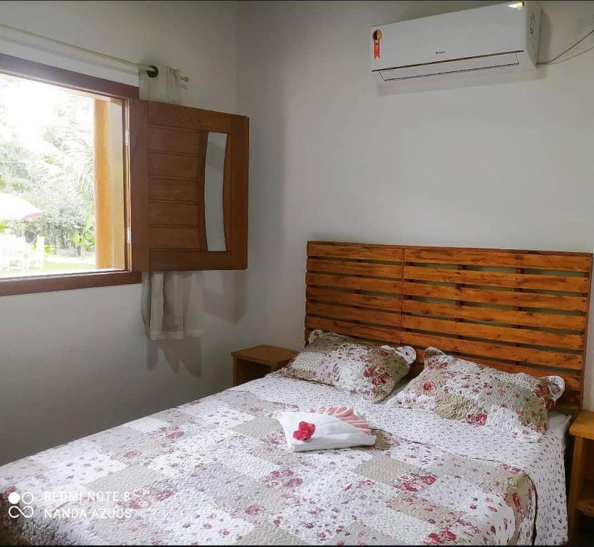 a bedroom with a bed with a dresser and a window at Chalés do Valle - Arraial D'ajuda in Porto Seguro