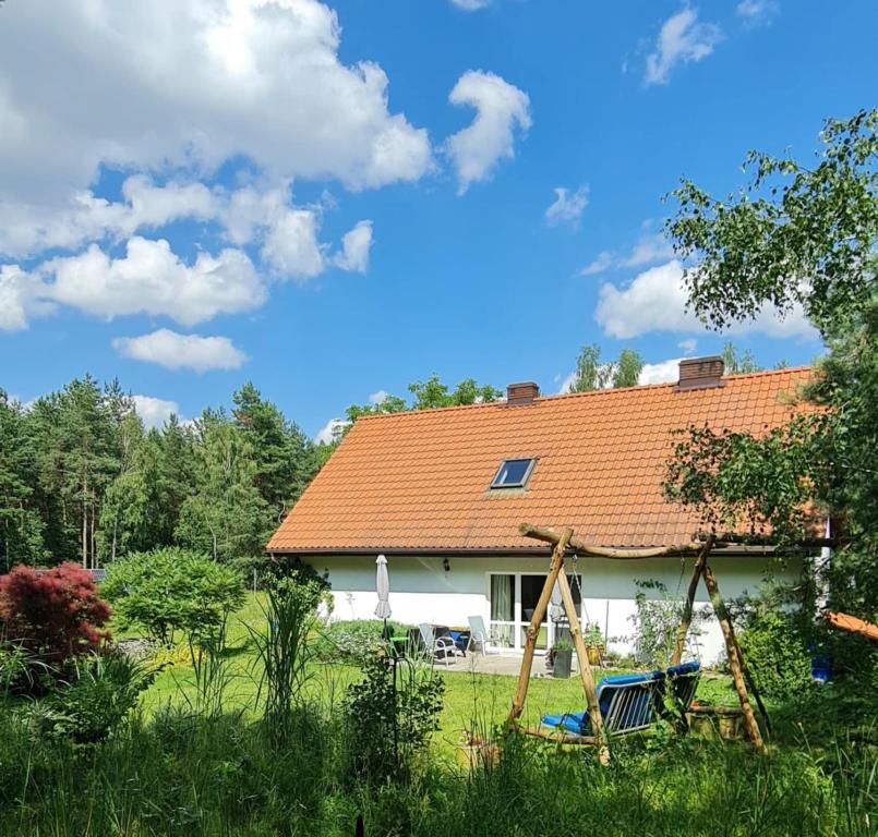 a white house with an orange roof at Agroturystyka TWÓJ KĄCIK in Kurzętnik