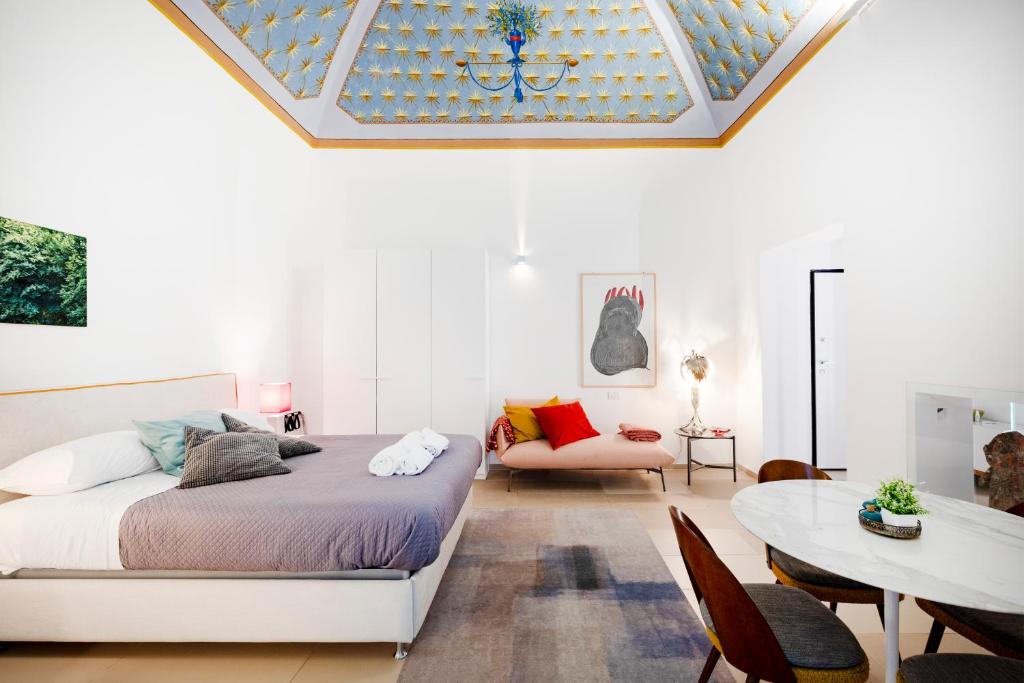 a bedroom with a bed and a table and chairs at Dimora Delle Stelle - Design & Heritage in Bari