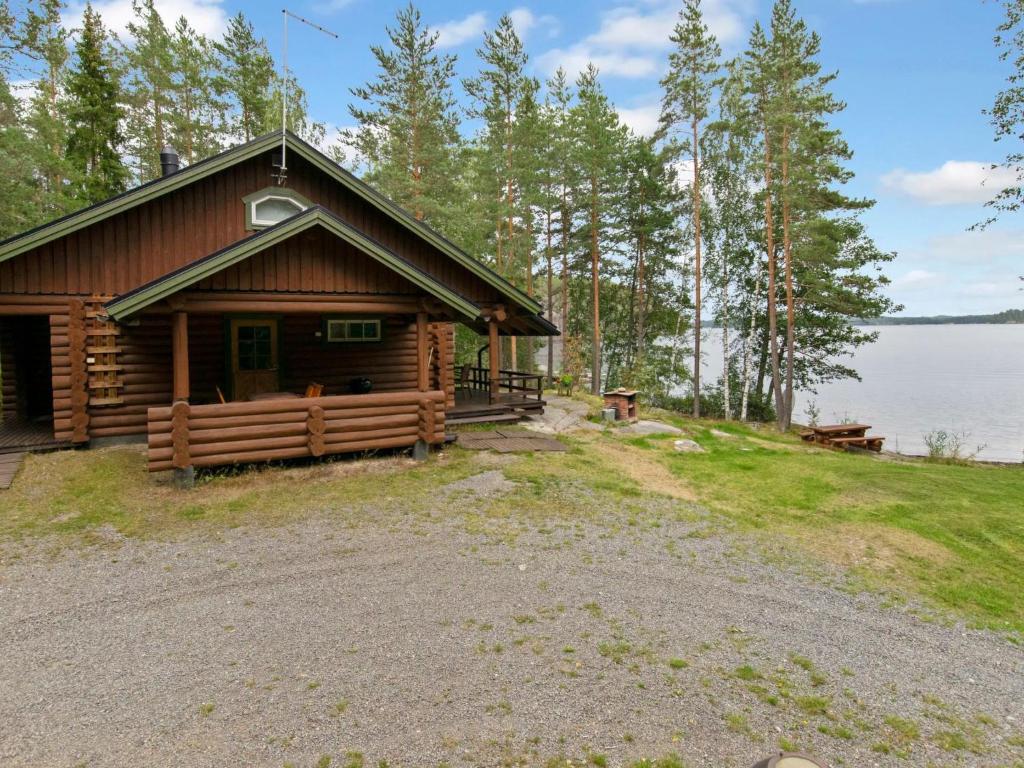 a log cabin on the shore of a lake at Holiday Home Ulappa by Interhome in Hurissalo