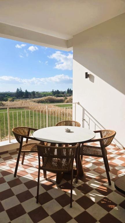 a patio with a table and chairs on a balcony at 1BR Serviced Apt with Pool & Premium Amenities in Oroklini