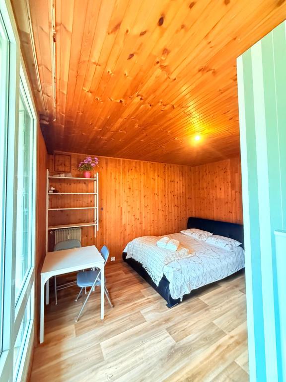 a bedroom with a bed and a desk in a room at Positive country in Aulnay-sous-Bois