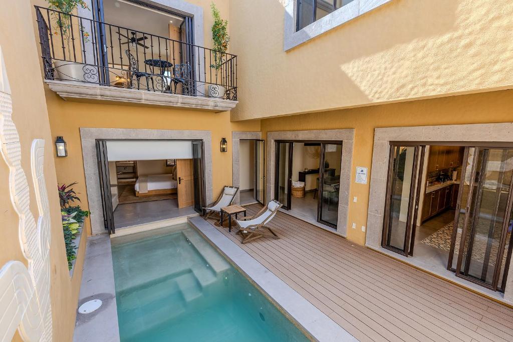 a house with a swimming pool and a balcony at Designer Retreat in Centro Heated Pool & Views in San Miguel de Allende