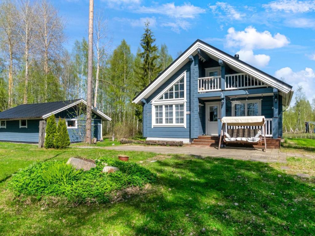 a blue house with a bench in the yard at Holiday Home Tuliniemi by Interhome in Iisalmi