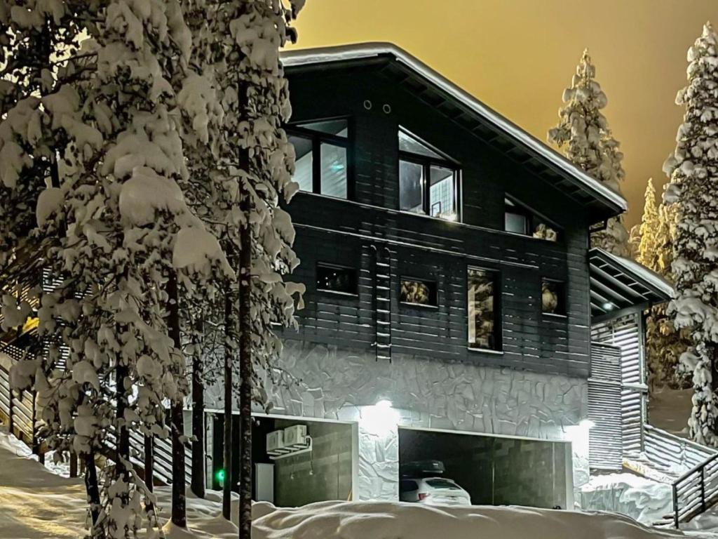 a log cabin in the snow with a tree at Holiday Home Villa arcus a by Interhome in Pelkosenniemi