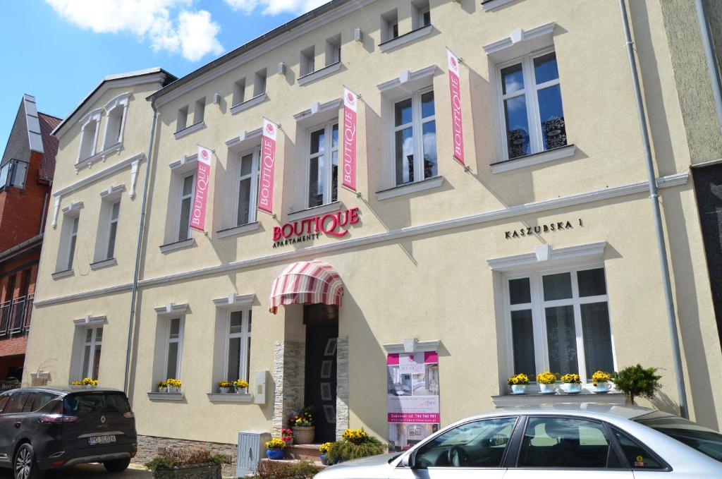 a building with a car parked in front of it at Apartamenty Boutique in Ustka