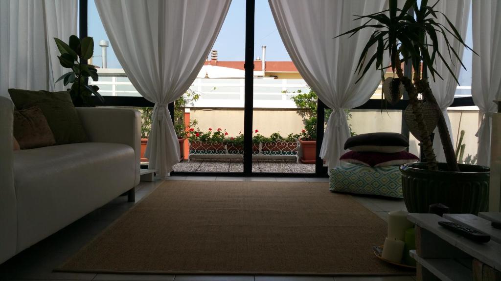 sala de estar con sofá y ventana con cortinas en Cristina' s flat, en Misano Adriatico