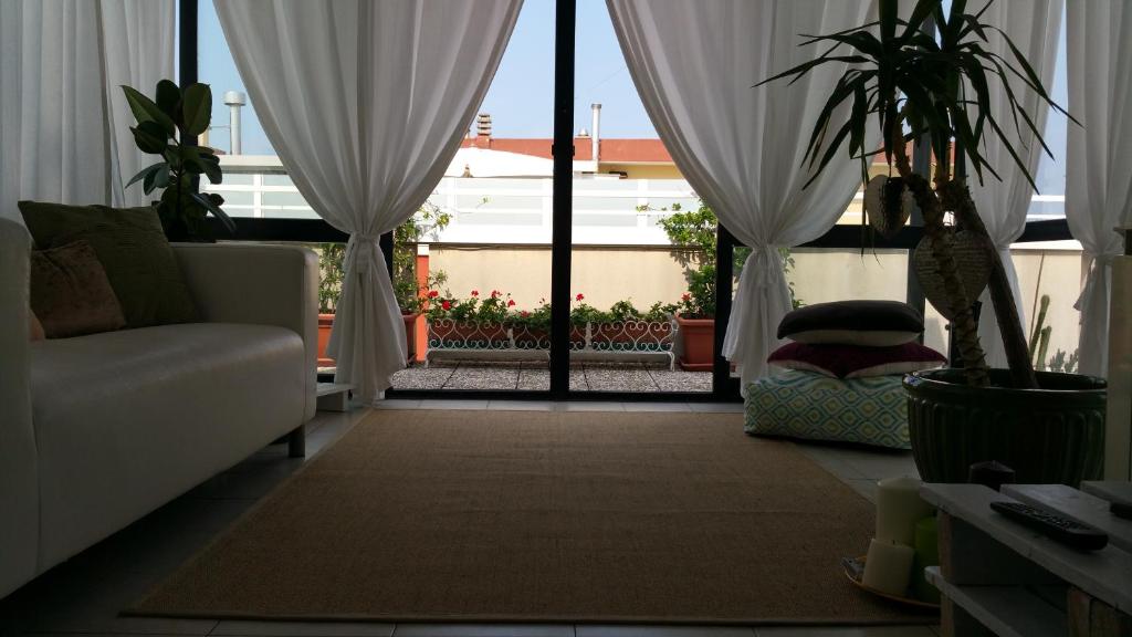 ミザーノ・アドリアーティコにあるCristina' s flatのリビングルーム(ソファ付)、窓(カーテン付)