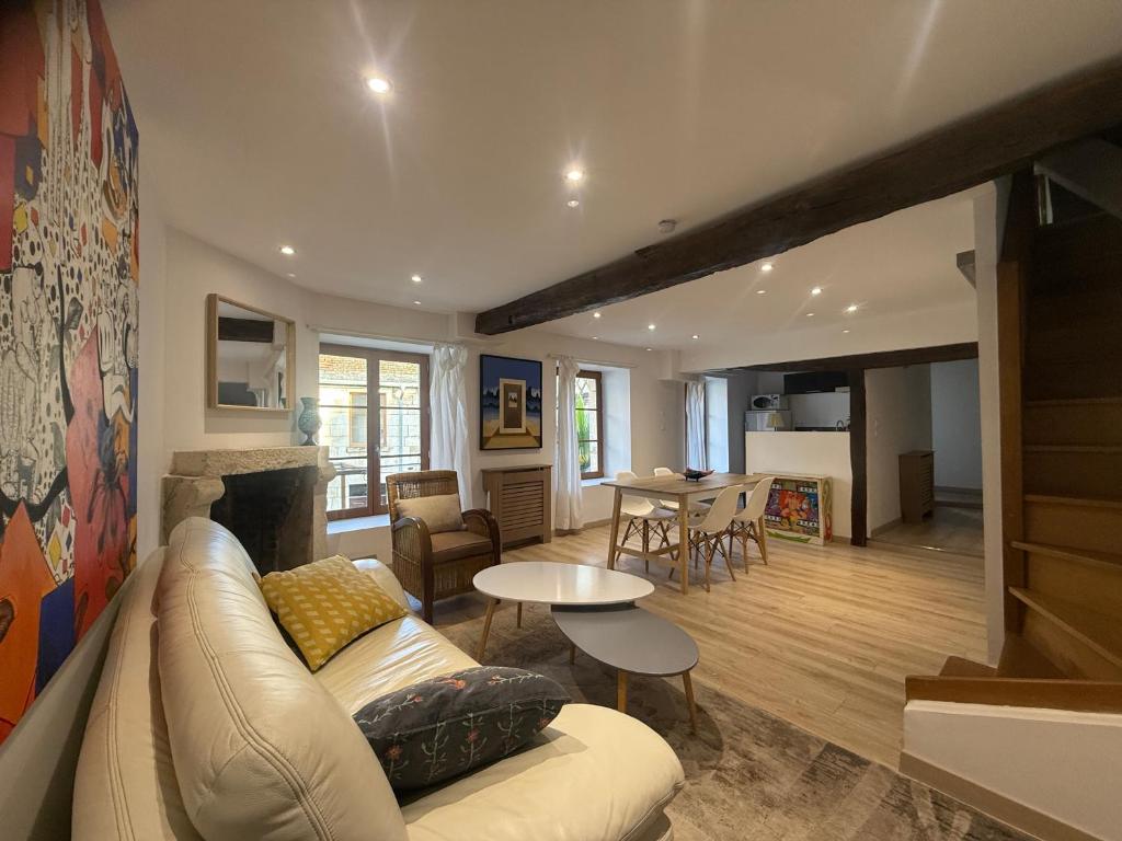 a living room with a couch and a table at La Galerie - Mini Piscine - Bourges Originale in Bourges