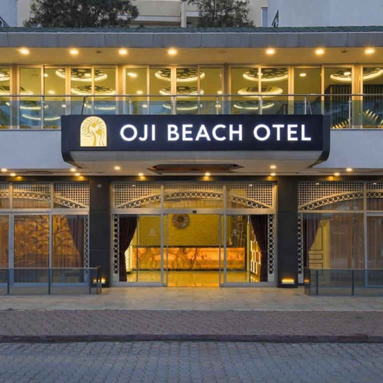 a building with a sign that reads oil beach outlet at Oji Beach Hotel in Hacılar