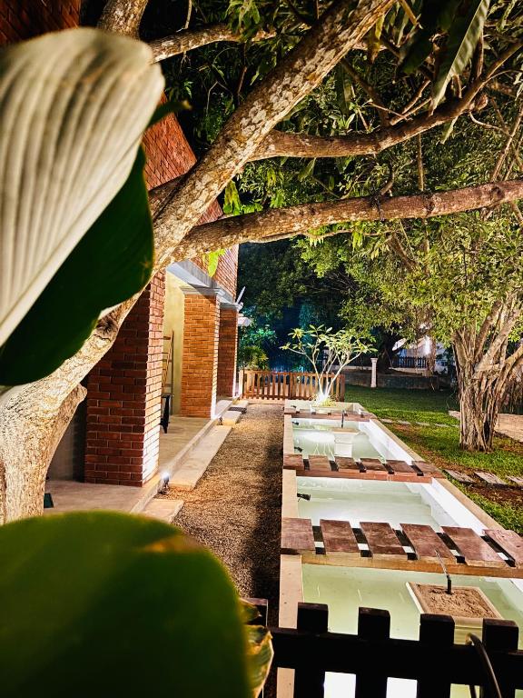 a courtyard with a row of tables and trees at Mount Side Hiriketiya in Hiriketiya