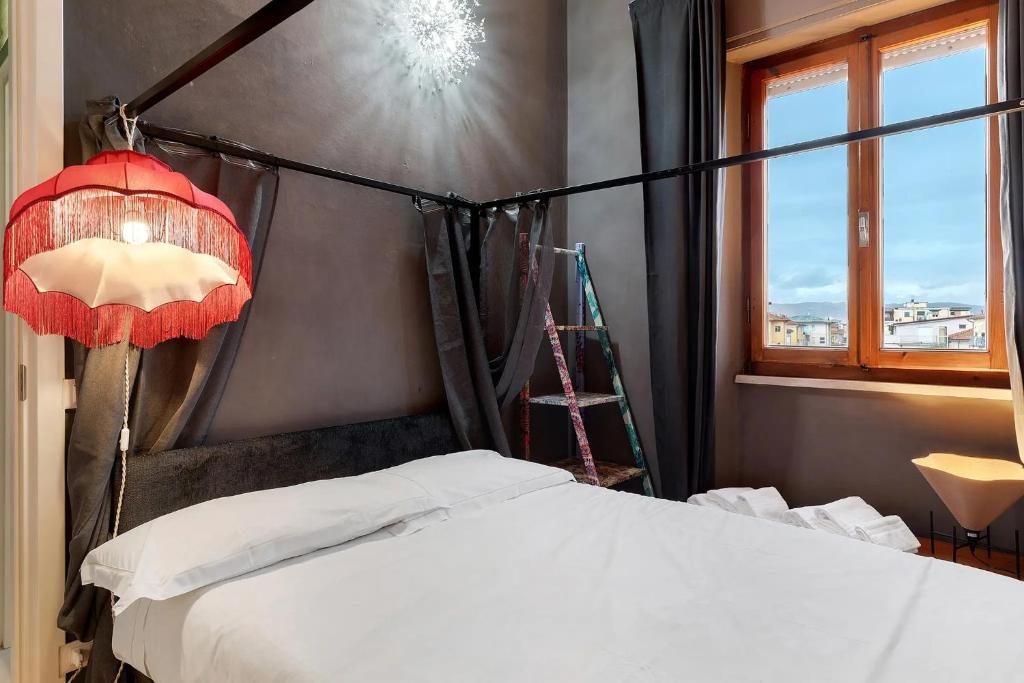 a bedroom with a bed and a lamp and a window at Mistral Holidays - Minisuite Centralissima in Marina di Carrara