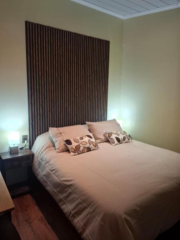 a bedroom with a bed with two pillows on it at My Refugio Wet Wet in Puerto Montt