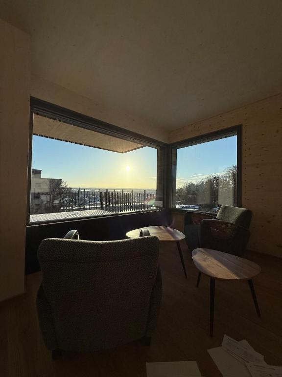 a living room with two chairs and a large window at Wohnen am Südhang in Amberg