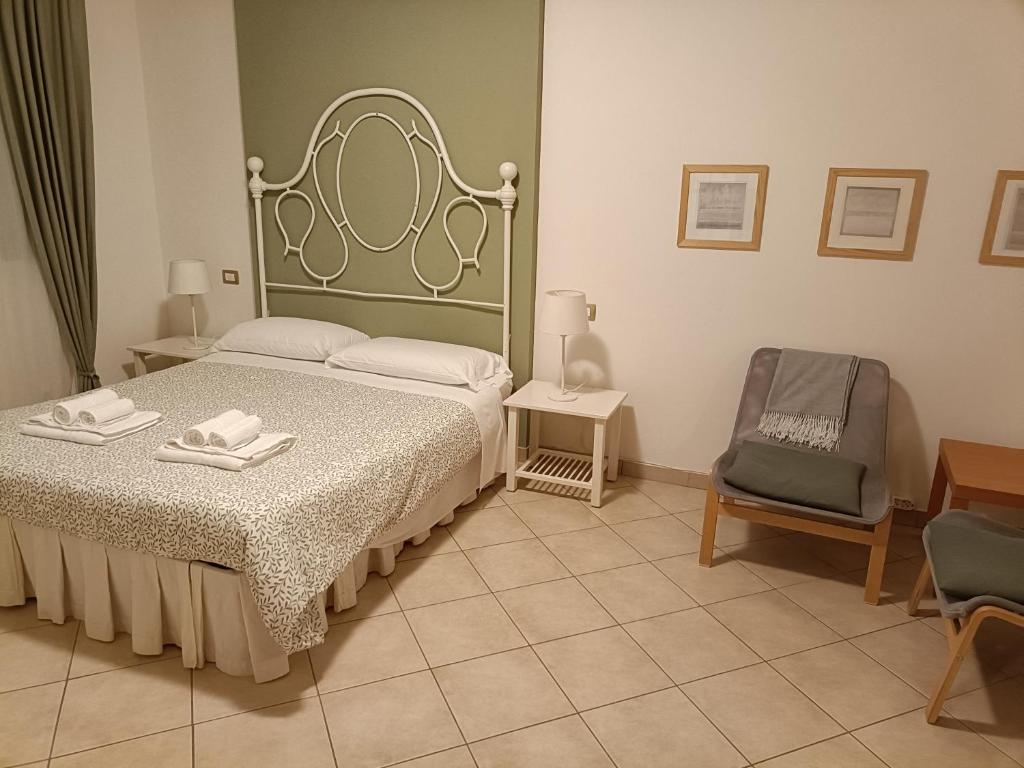 a bedroom with a bed and a chair at La casetta di Nonno Carlo a due passi dall'ospedale in Torrette
