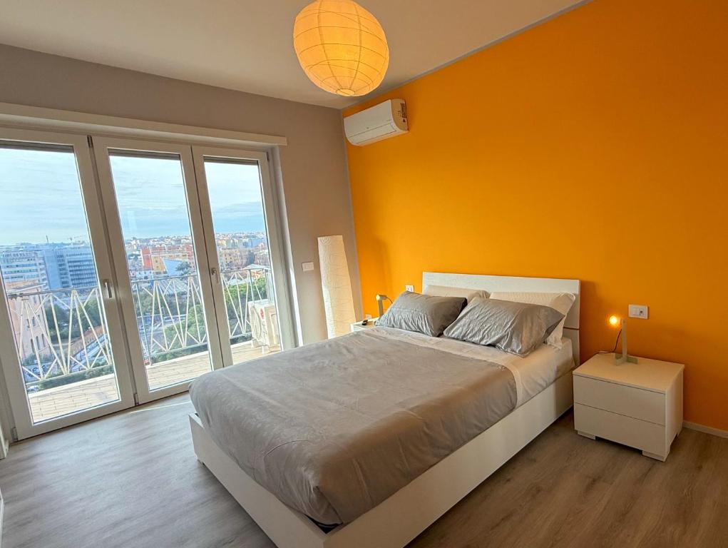 a bedroom with a large bed with orange walls and windows at Garba Stop in Rome