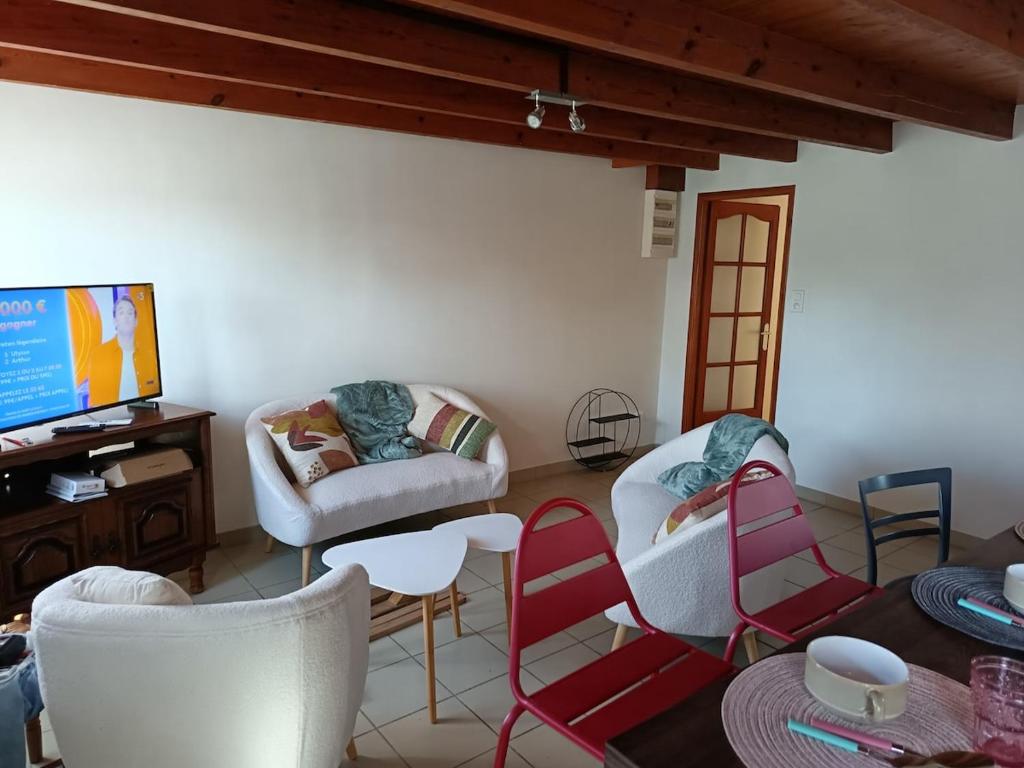 a living room with chairs and a couch and a tv at maison Le Wetz in Sainte-Marie-Kerque