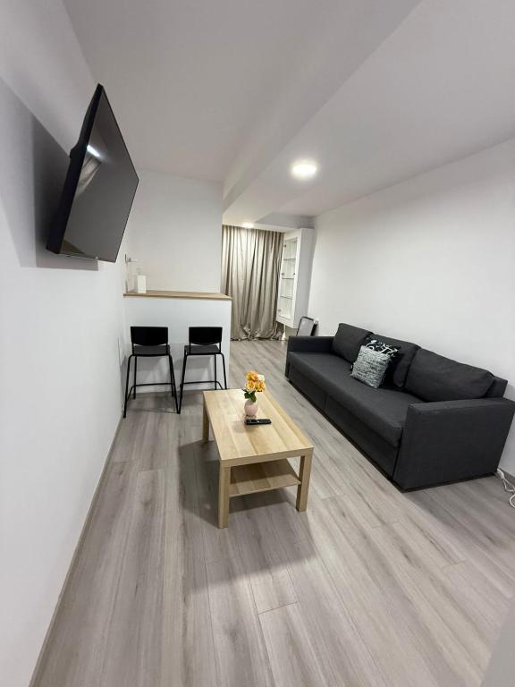 a living room with a black couch and a table at Limassol center Soul in Limassol