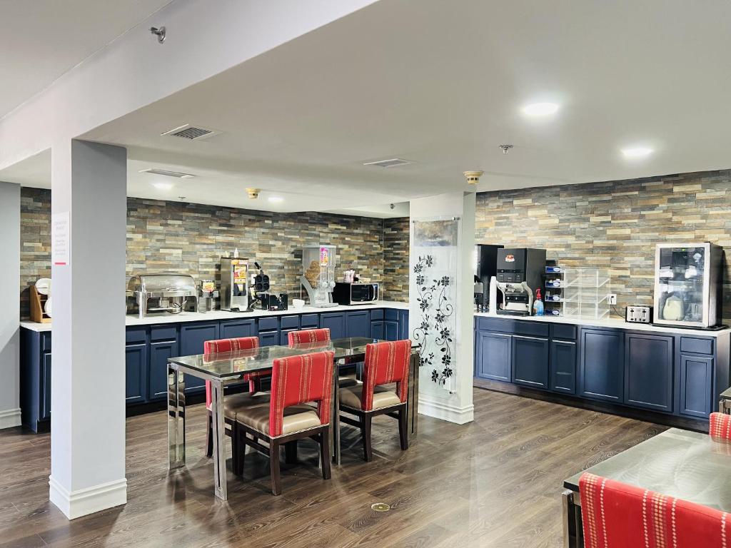 a dining room with blue cabinets and red chairs at AmericInn by Wyndham Rawlins in Rawlins