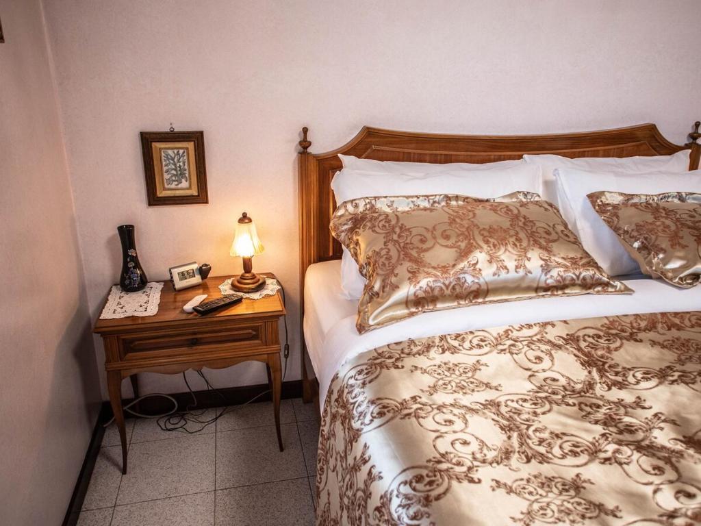 a bedroom with a bed and a table with a lamp at Frank & Giuly House in Rivoli