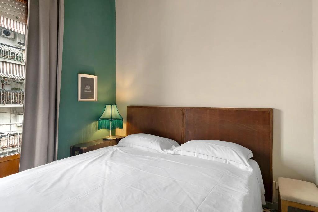 a bedroom with a white bed with a wooden headboard at Mistral Holidays - Minisuite Marina in Marina di Carrara