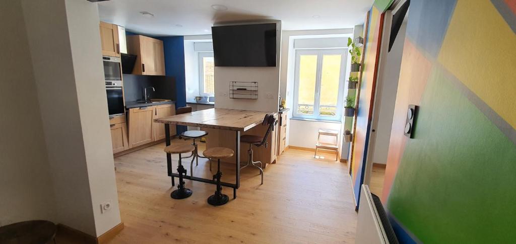 a kitchen with a table and chairs in a room at Appartement La Perle Du Sancy in La Bourboule