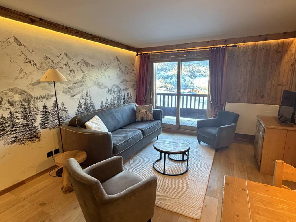 a living room with a blue couch and chairs at Appartement 4* - Pied des pistes - Piscine, Spa, Sauna, Hammam, Salle de sport - FR-1-461-24 in Saint-Martin-de-Belleville