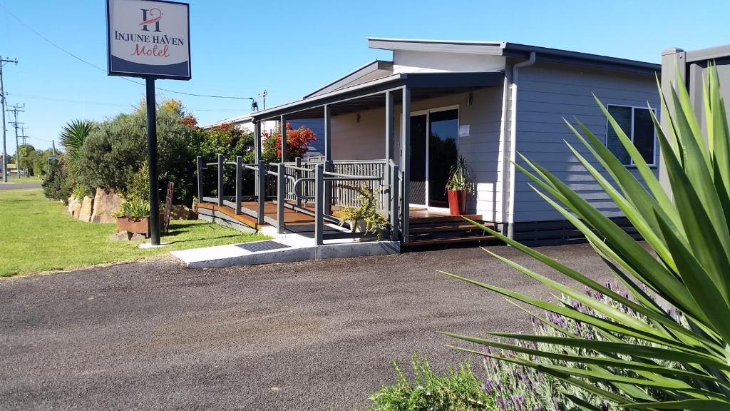 una pequeña casa con un cartel delante en Injune Haven en Injune