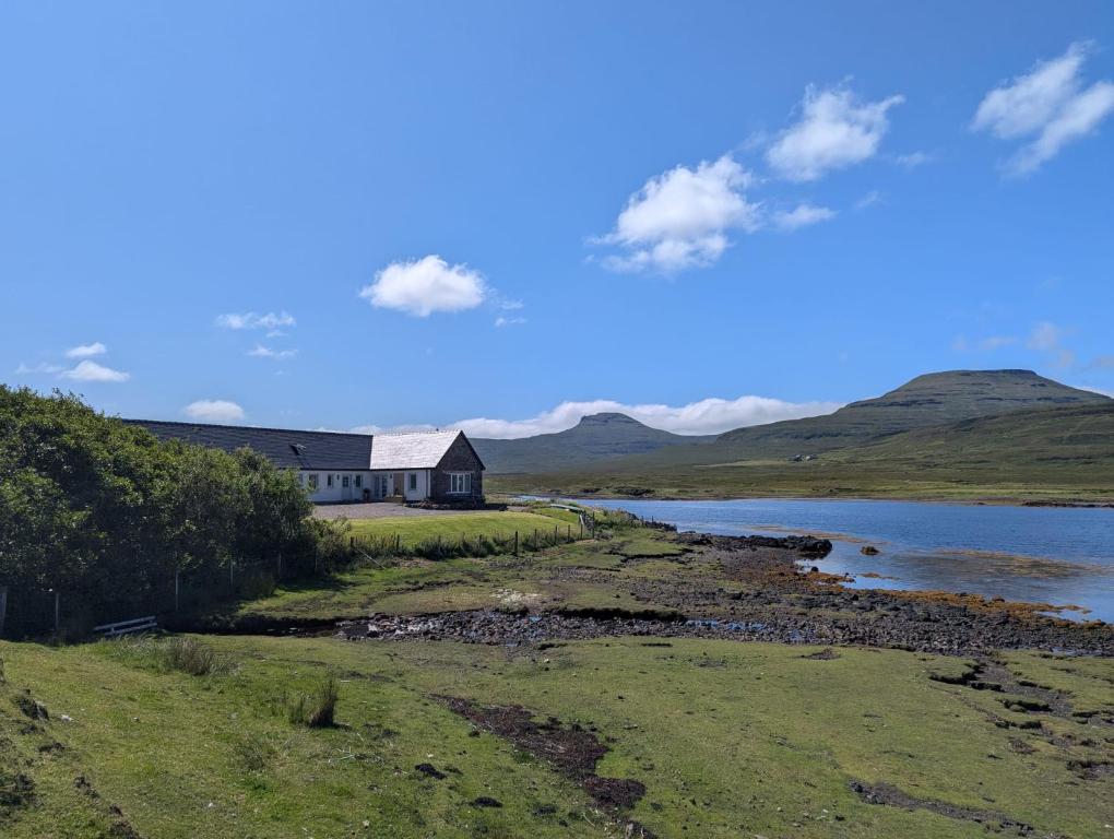 a house on a hill next to a river at Dunvegan Steading Bed and Breakfast in Dunvegan