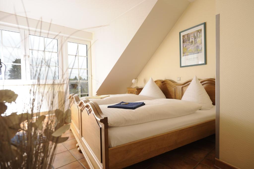 a bedroom with a bed with white sheets and a window at Gasthof Robens in Dormagen