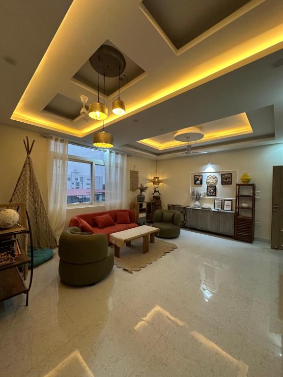 a living room with a red couch and a table at Simbas Den by Abodeandco in Dehradun